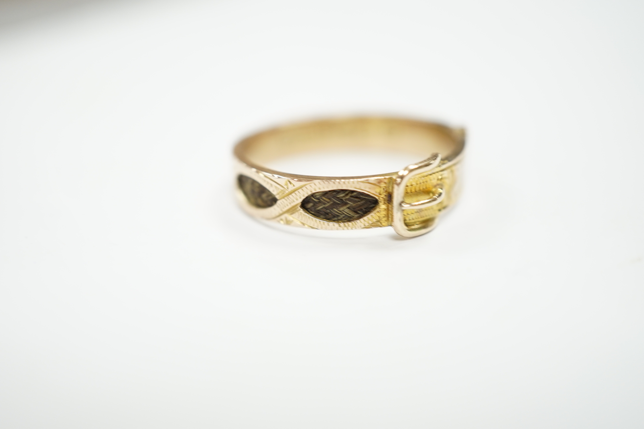 A late Victorian 9ct gold and inset hair mourning buckle ring, size U, gross weight 2.2 grams.